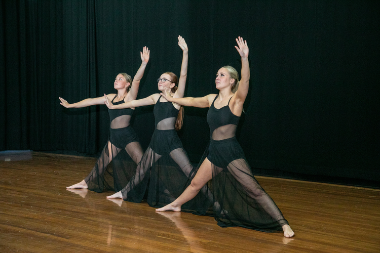 Three dancers performing on stage