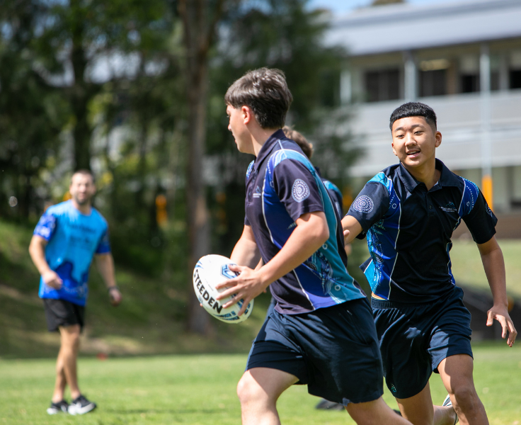 Boys playing rugby on school oval